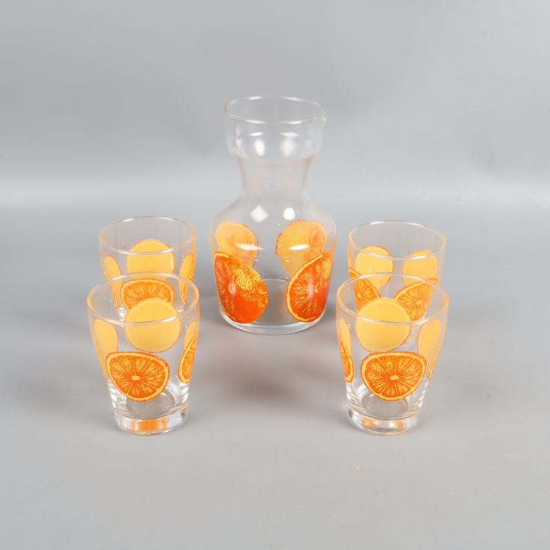 Karaff och fyra glas uppställda tillsammans på rad