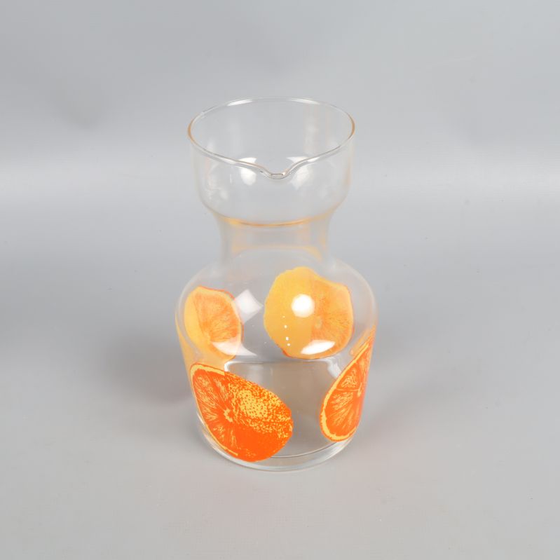 Transparent karaff med färgglada apelsinmotiv