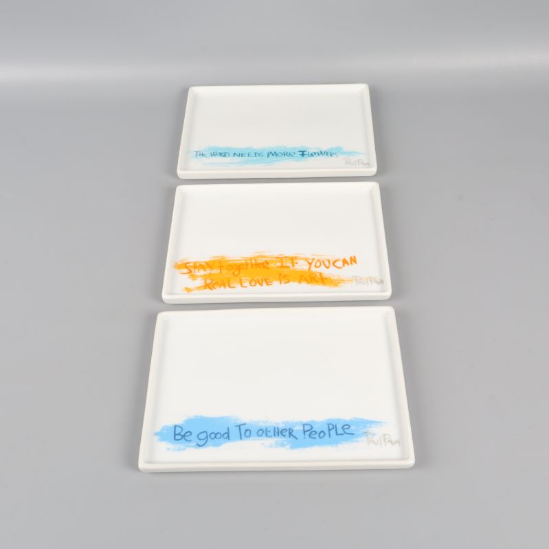 Tre rektangulära fat med blå och orange text i rad