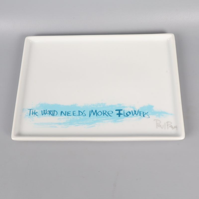 Närbild av fat med blå texten The world needs more flowers