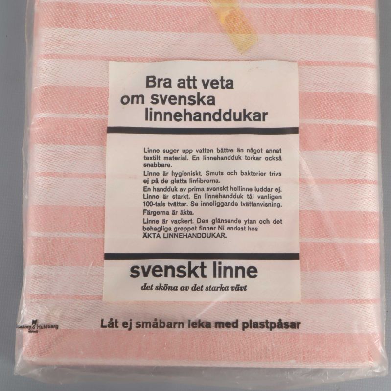 Närbild av informationsetikett om linnehanddukar på baksidan