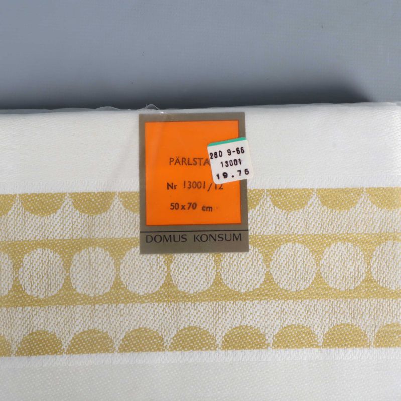 Närbild av etikett och pärlmönster på handduk