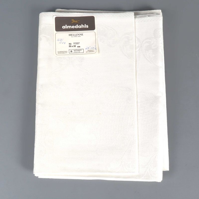 Vikt vit linneservett med etikett från almedahls