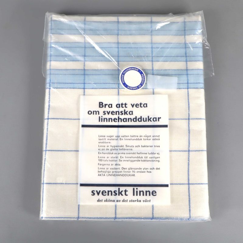 Baksidan av förpackad blåvit kökshandduk med informationsblad