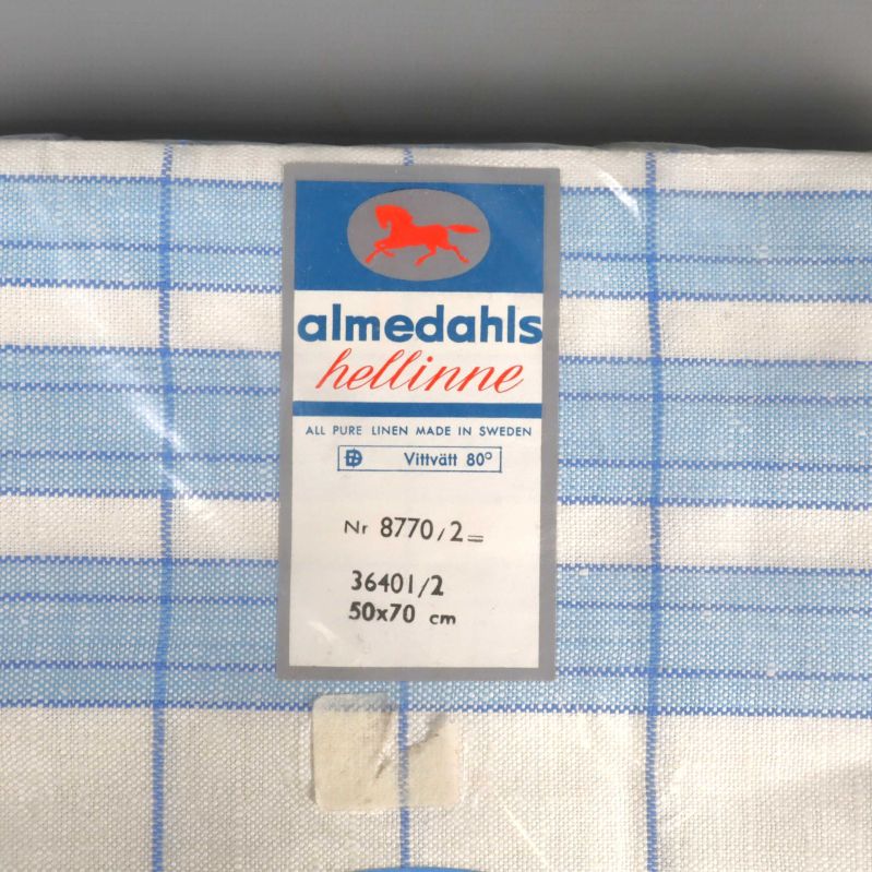 Närbild på Almedahls etikett och handdukens rutiga mönster