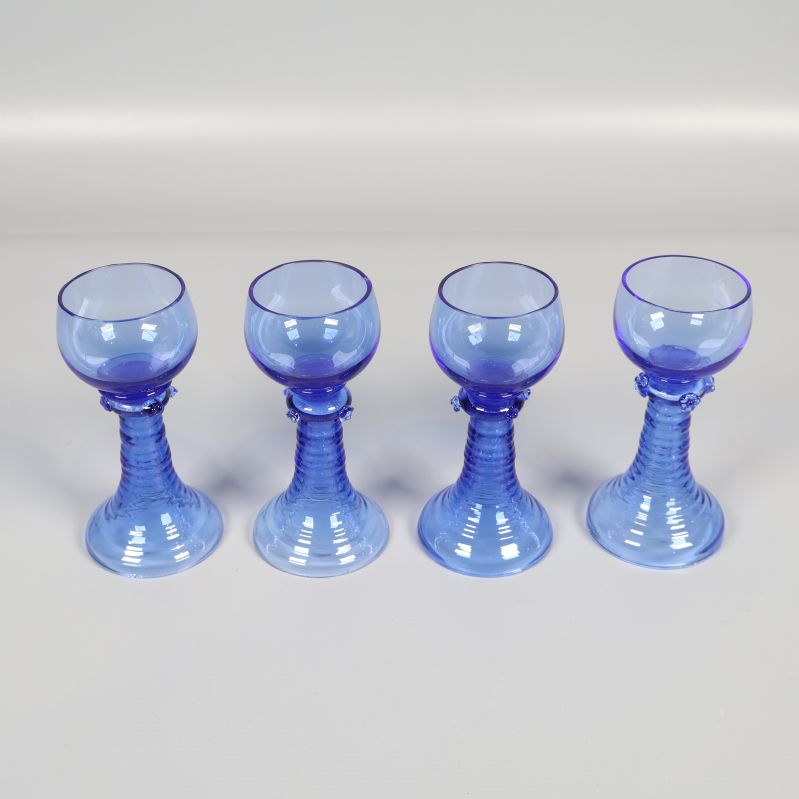 Fyra blå snapsglas i rad