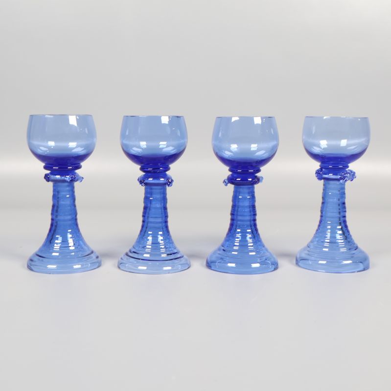 Fyra blå snapsglas i rad