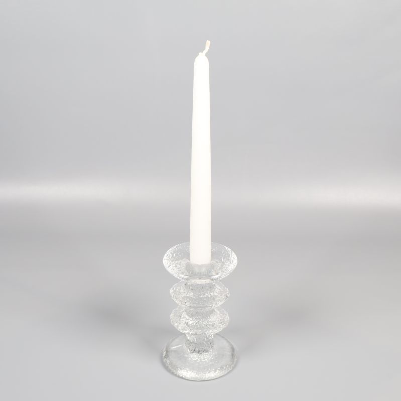 Hög glasljusstake med stearinljus på grå bakgrund