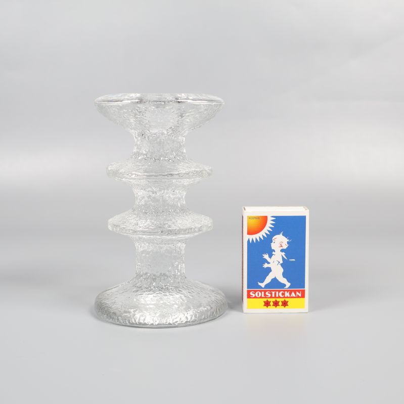 Glasljusstake bredvid tändsticksask för storleksjämförelse