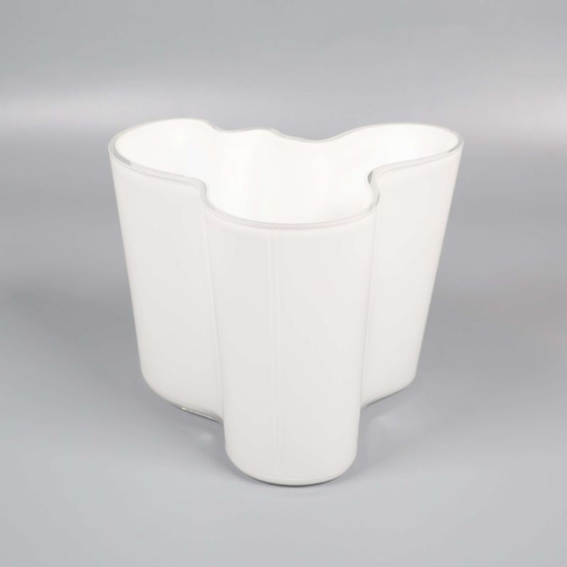 Vit tulpanvas med vågig kant mot grå bakgrund