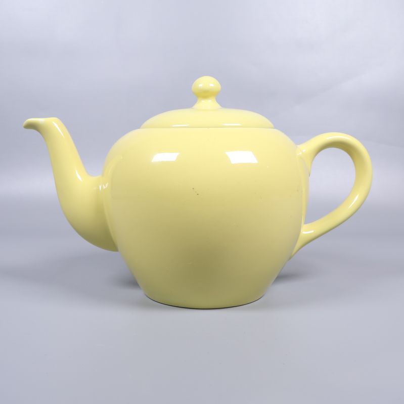 Tekanna i gult porslin sedd från sidan