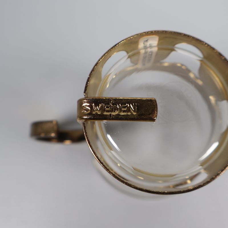 Närbild på glasmugg med präglad text Sweden på hållaren