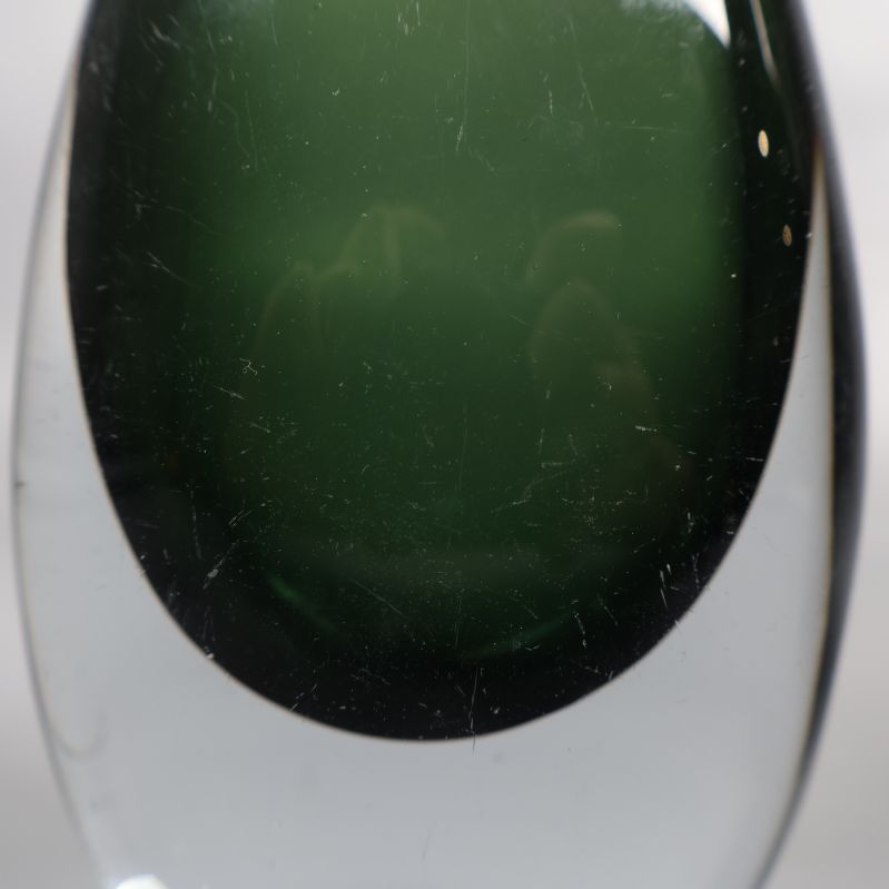 Närbild på grön glasvas med synliga repor