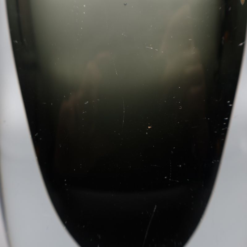 Närbild på större glasvas med synliga repor