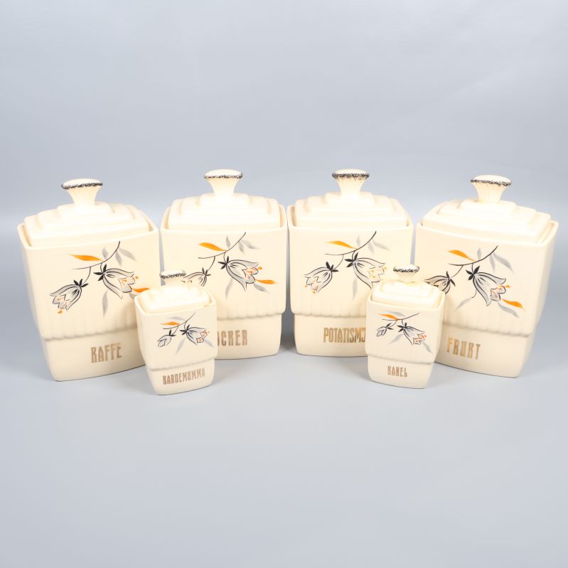 Sex krämfärgade förvaringsburkar med blommönster och texter
