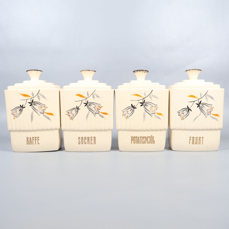 Fyra stora förvaringsburkar med handmålade blommor uppradade