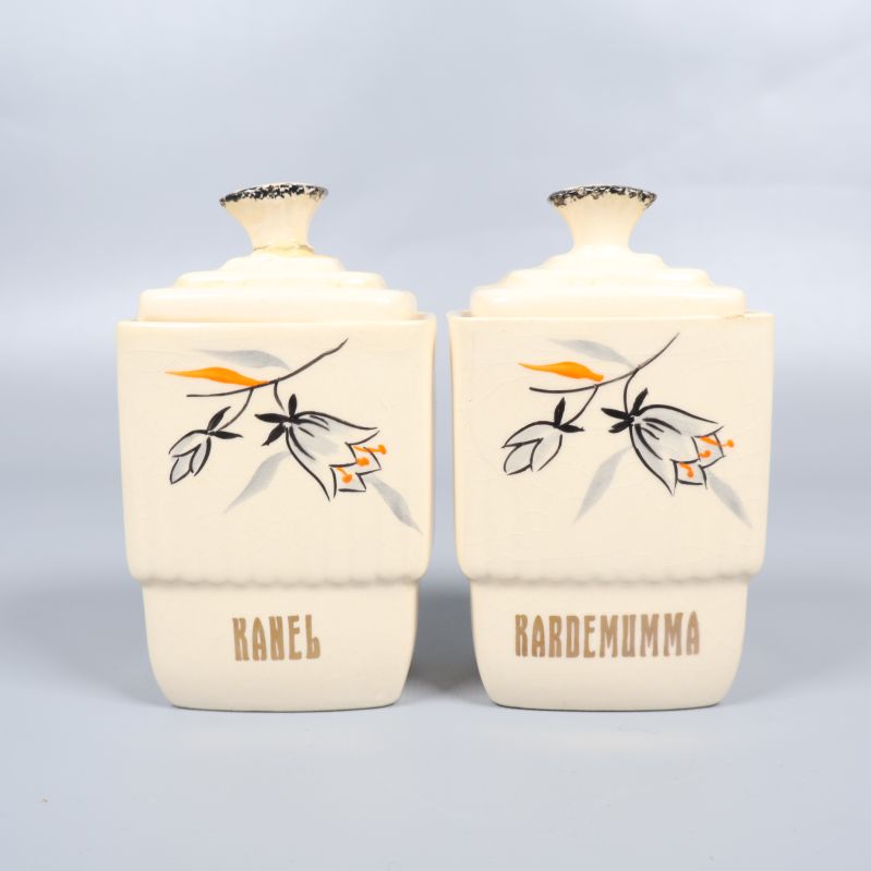 Två mindre förvaringsburkar med dekor och text kanel, kardemumma