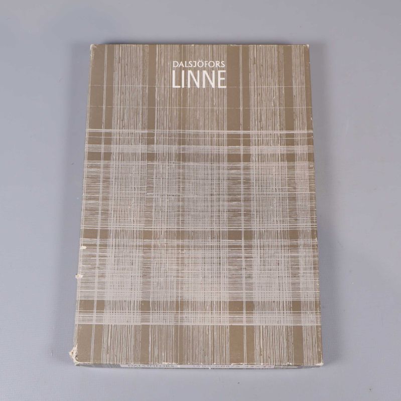 Kartong med texten Dalsjöfors Linne i rutigt mönster