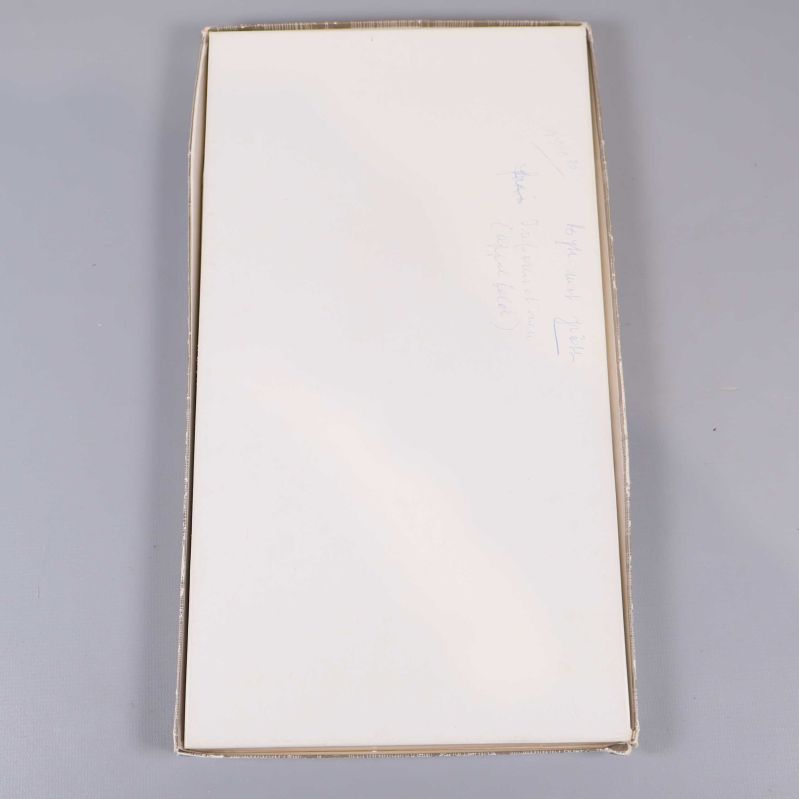 Vit baksida av kartongen med handskriven anteckning