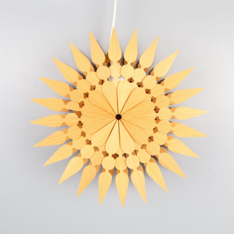 Julstjärna i trä med dekorativt mönster framifrån