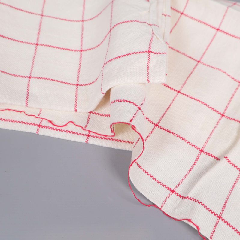 Närbild på tygkant och söm i rött på handduk