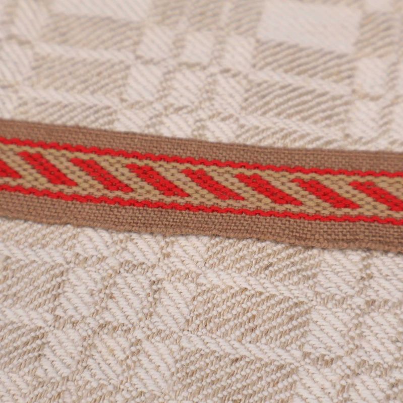 Detaljbild på röd bård med diagonala ränder på handduken