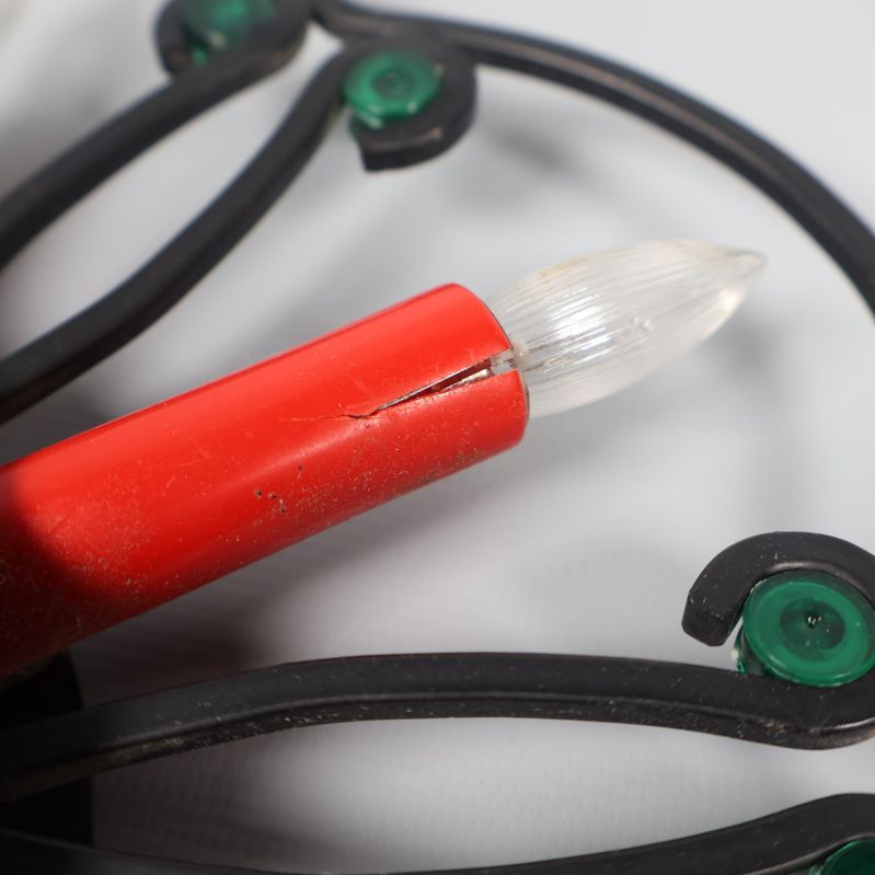 Närbild på sprucken röd ljusarm och glödlampa