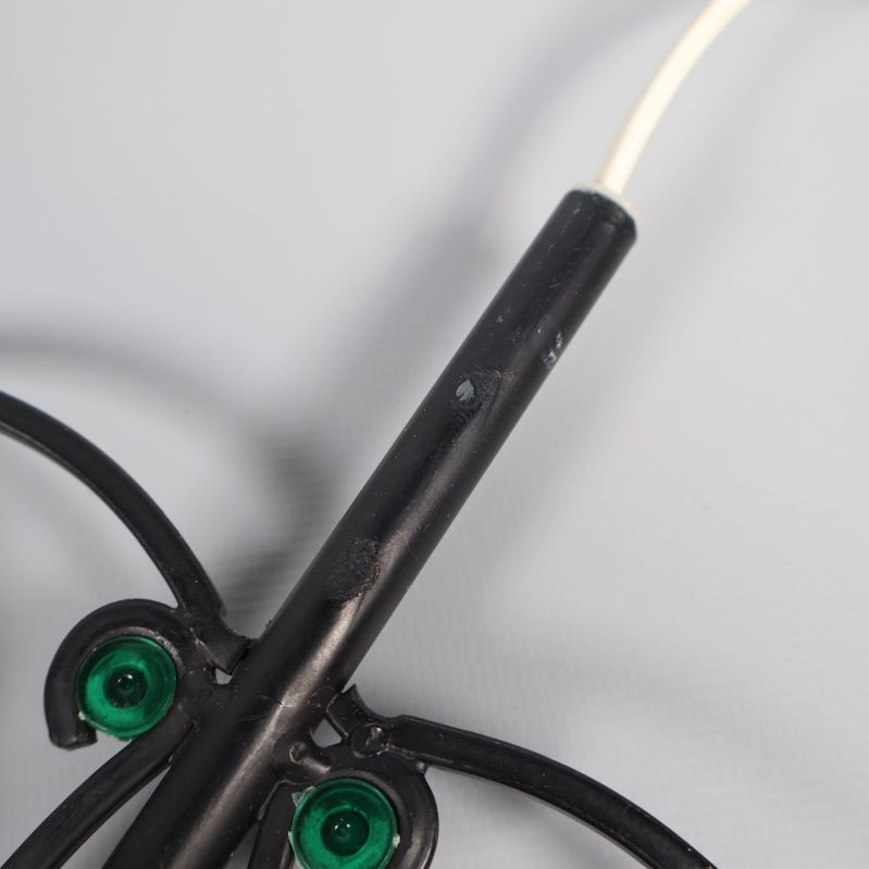 Närbild på svart metallfäste med små färgslitage