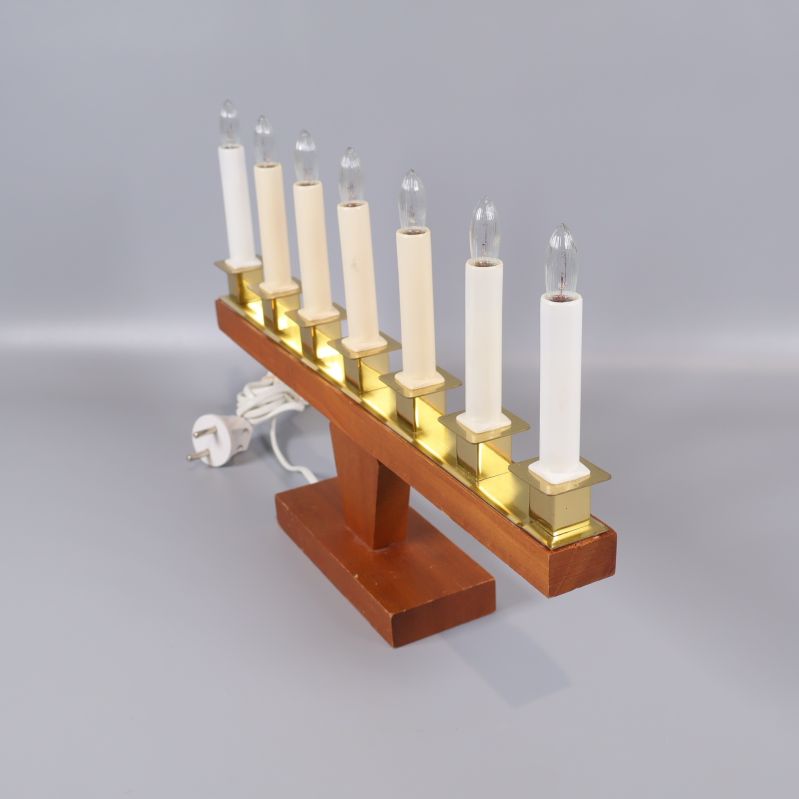 Elektrisk ljusstake i trä och mässing sedd snett framifrån