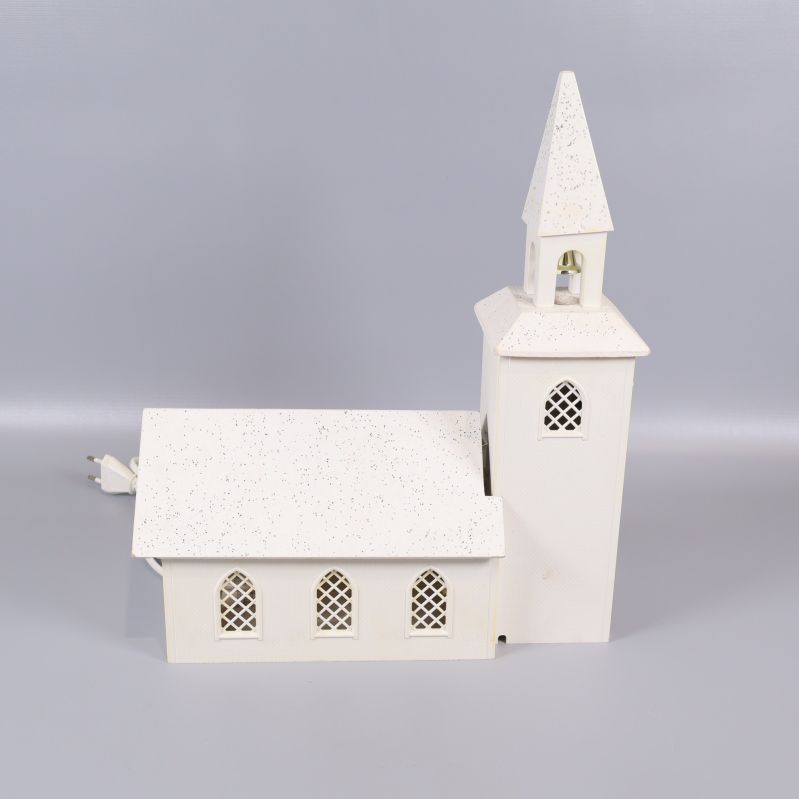 Vit kyrkformad lampa med spetsigt torn och dekorativa fönster