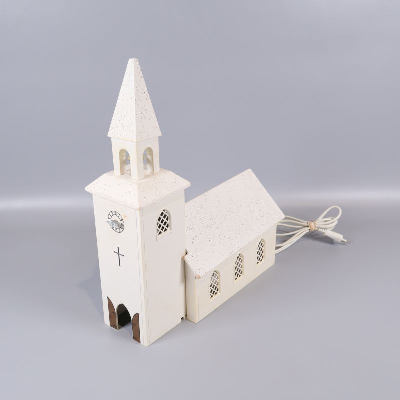 Kyrkformad lampa sedd framifrån, visar kors och klocktorn