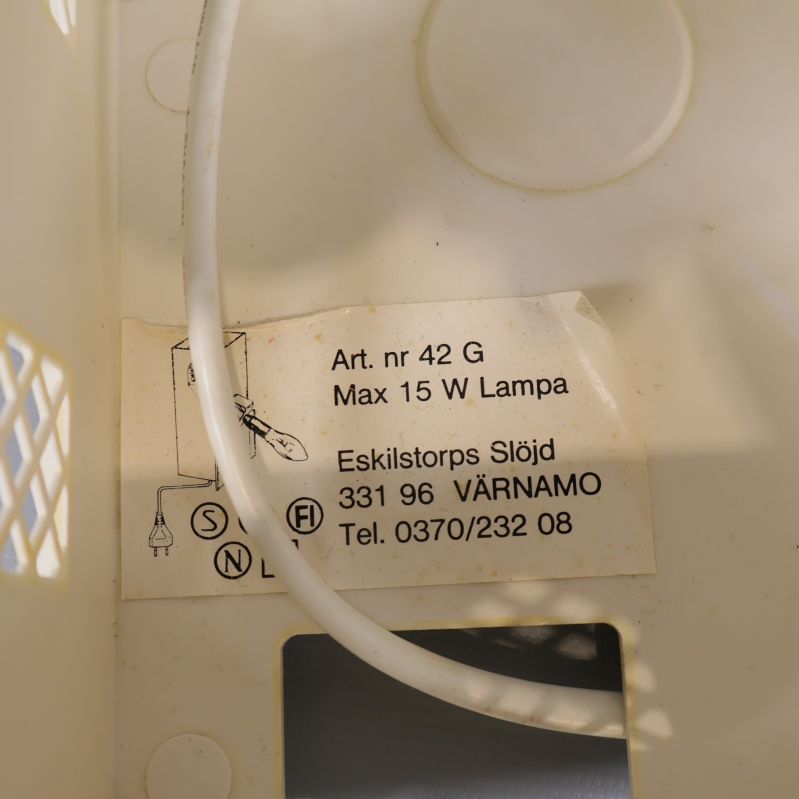 Närbild etikett inuti lampan med information om tillverkare