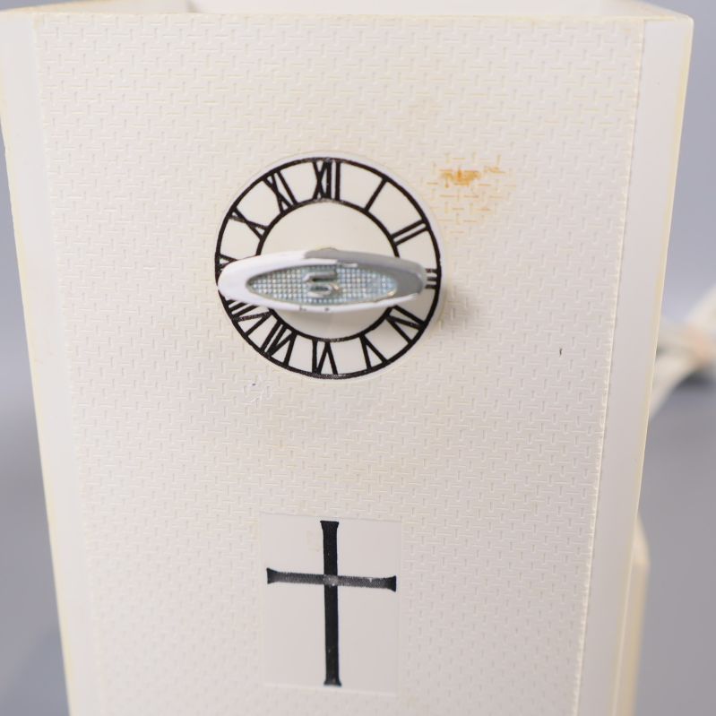 Klocktorn på kyrklampan med urtavla och kors