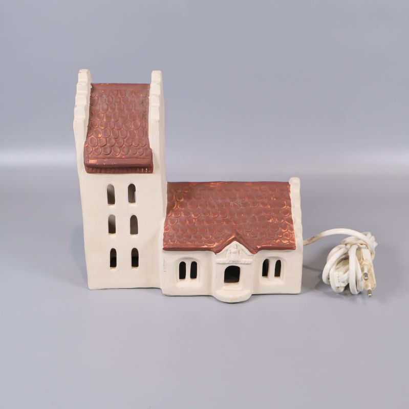 Keramikhus med vit fasad och brunrött tak samt elsladd