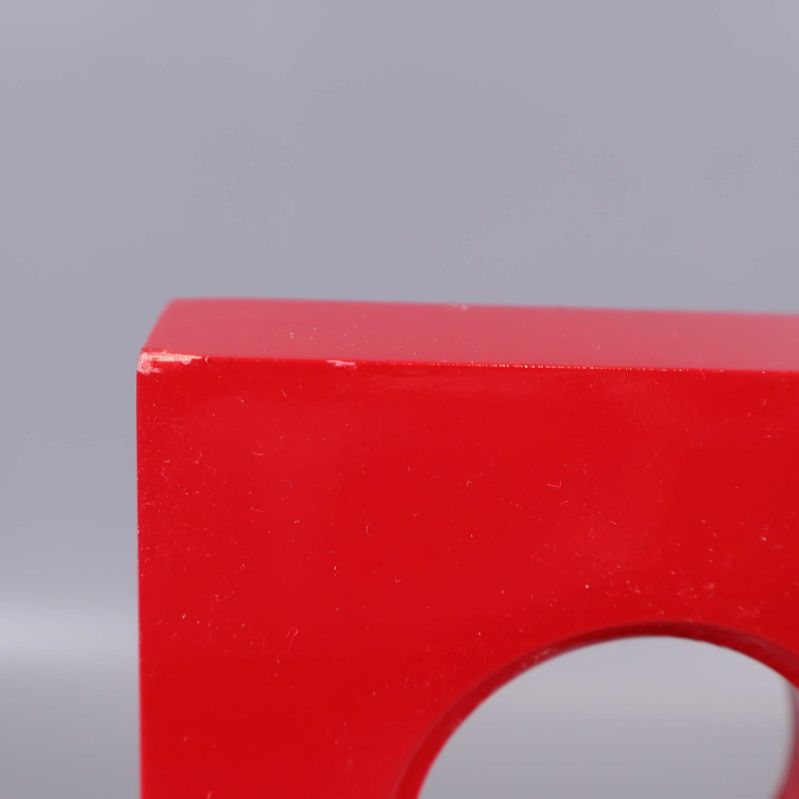 Närbild på kant av röd elljusstake med färgavskav