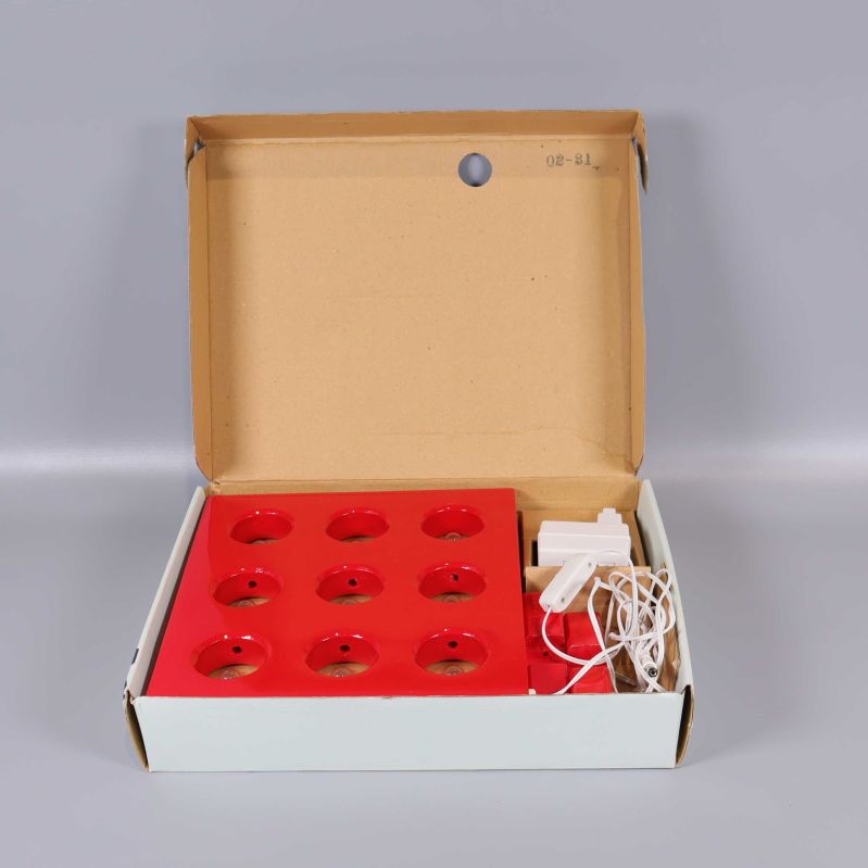 Öppen kartong med elljusstake och sladd i förpackning