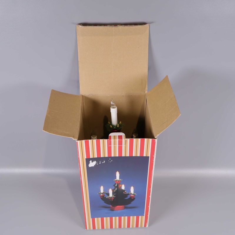 Adventsljusstake nedsänkt i kartong med öppen förpackning