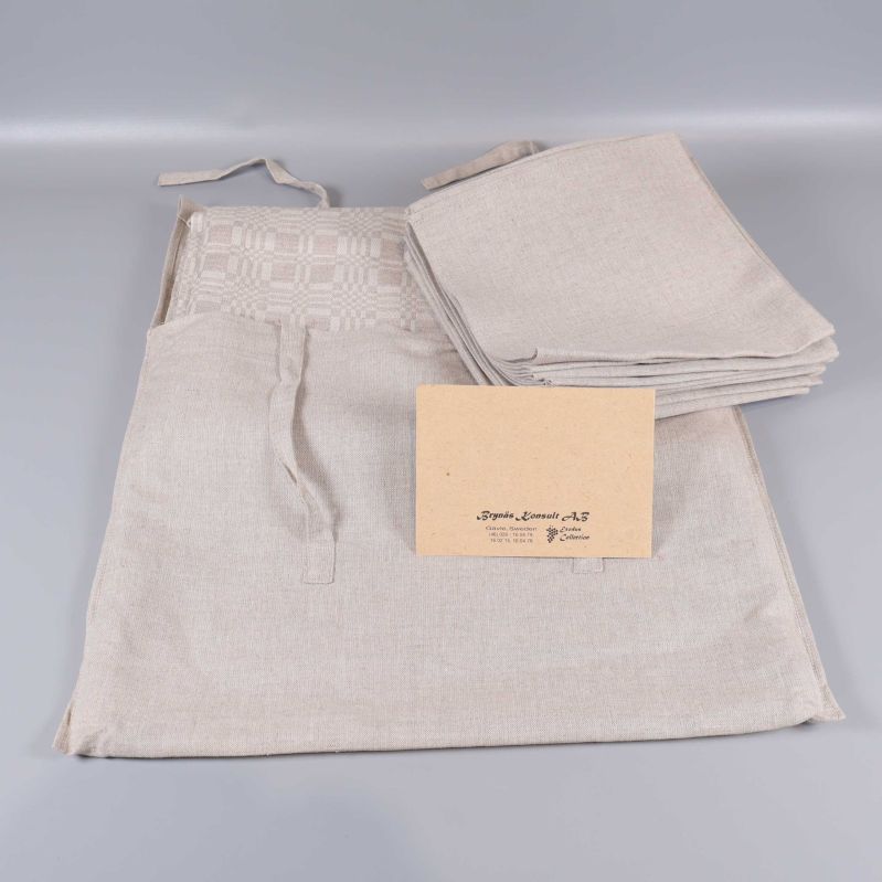 Beige duk i dräll och servetter i tygpåse med etikett