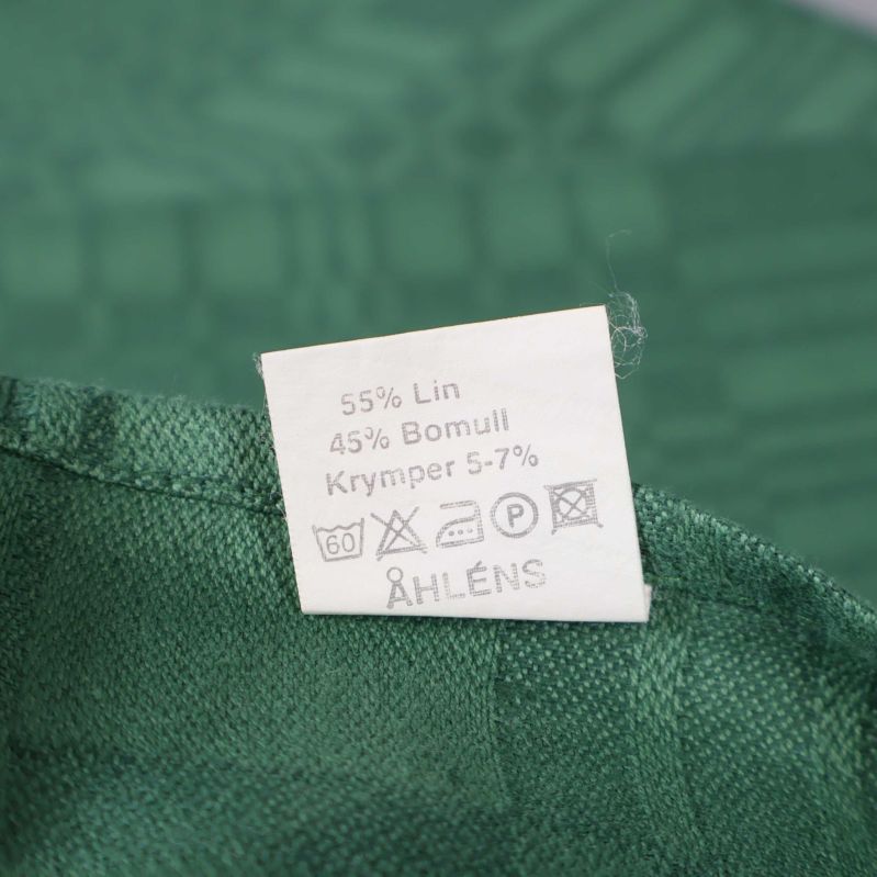 Materialetikett visar lin och bomull Åhléns