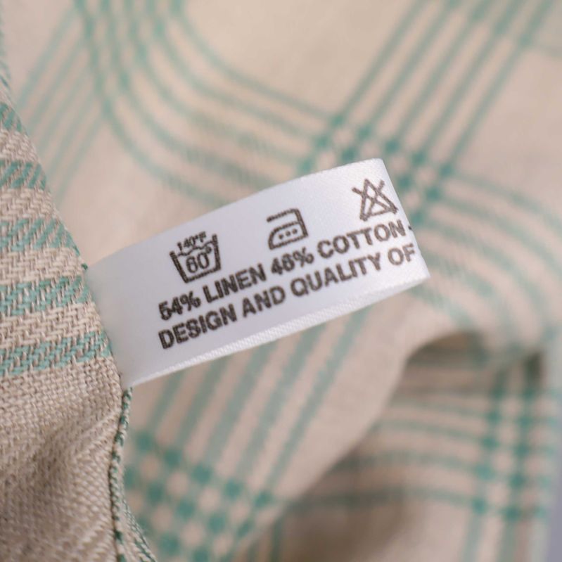 Materialetikett på duk visar lin och bomull