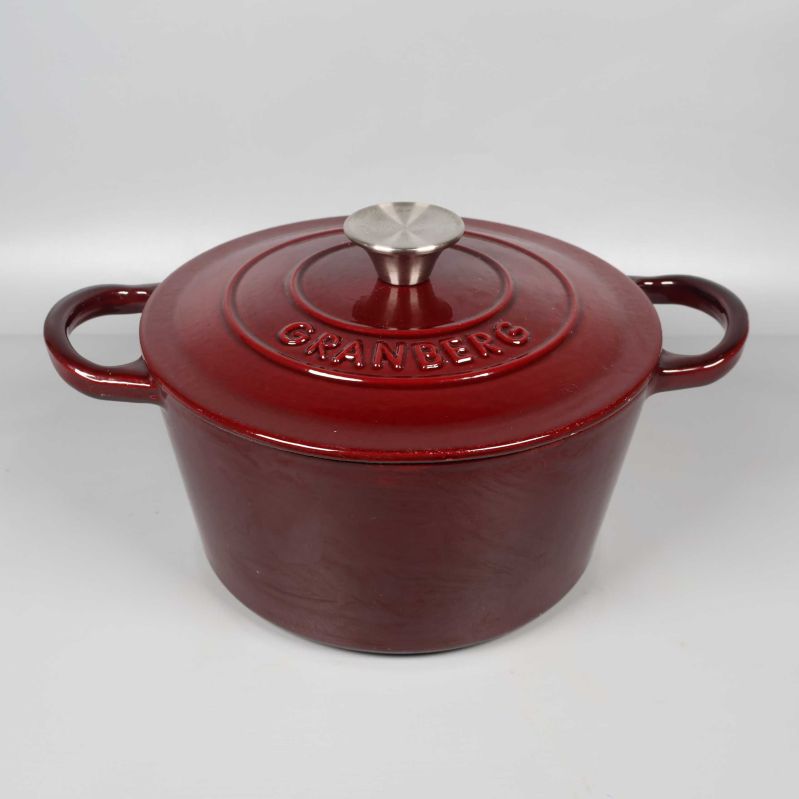 Röd gjutjärnsgryta med lock och två handtag