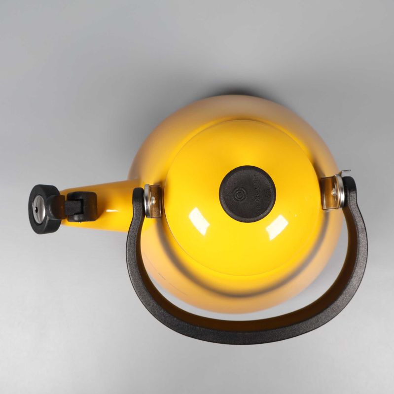 Toppvy på vattenkittel med stort svart handtag och lock