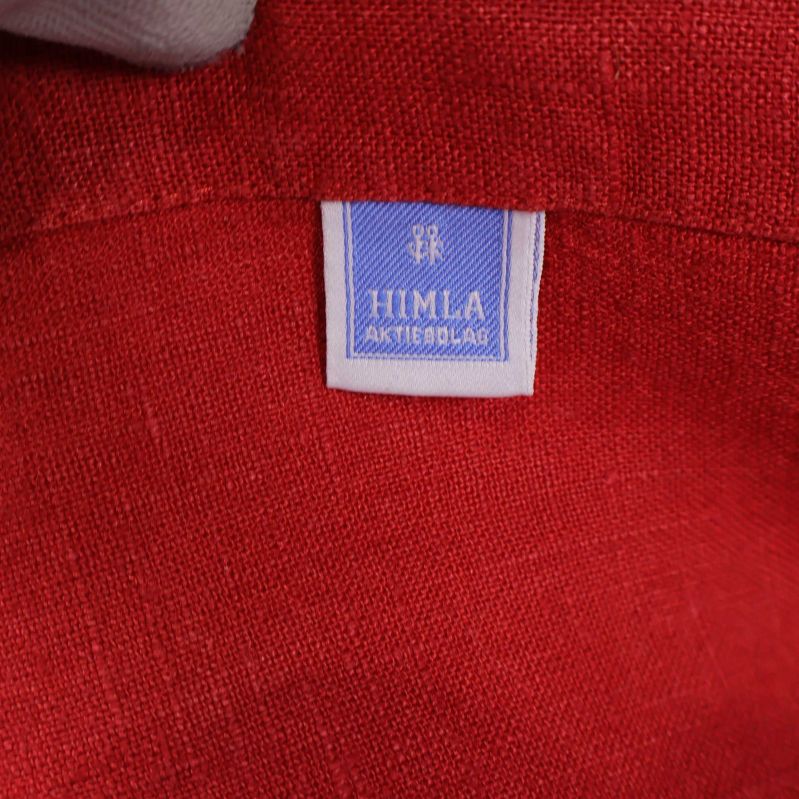 Närbild på blå Himla etikett på röd servett