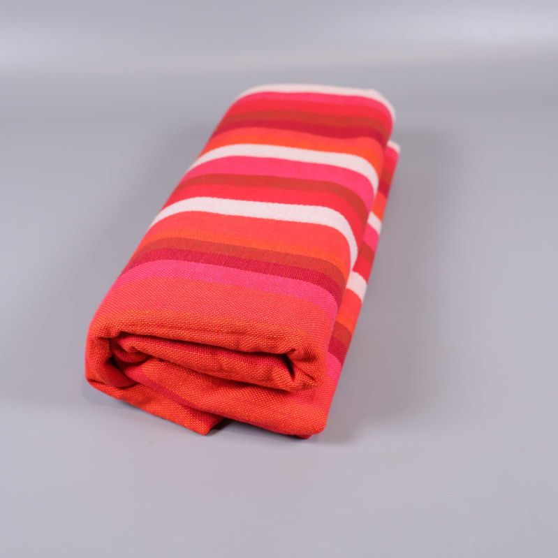 Randig duk ihoprullad med synliga röda och rosa ränder