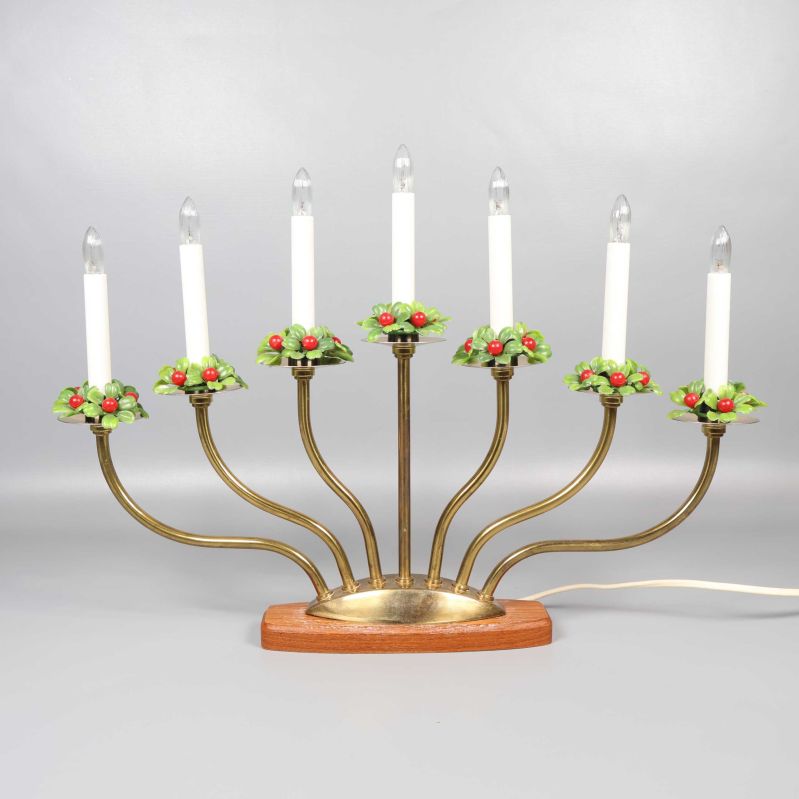 Ljuslyktan framifrån med alla sju ljus tända och dekorerade