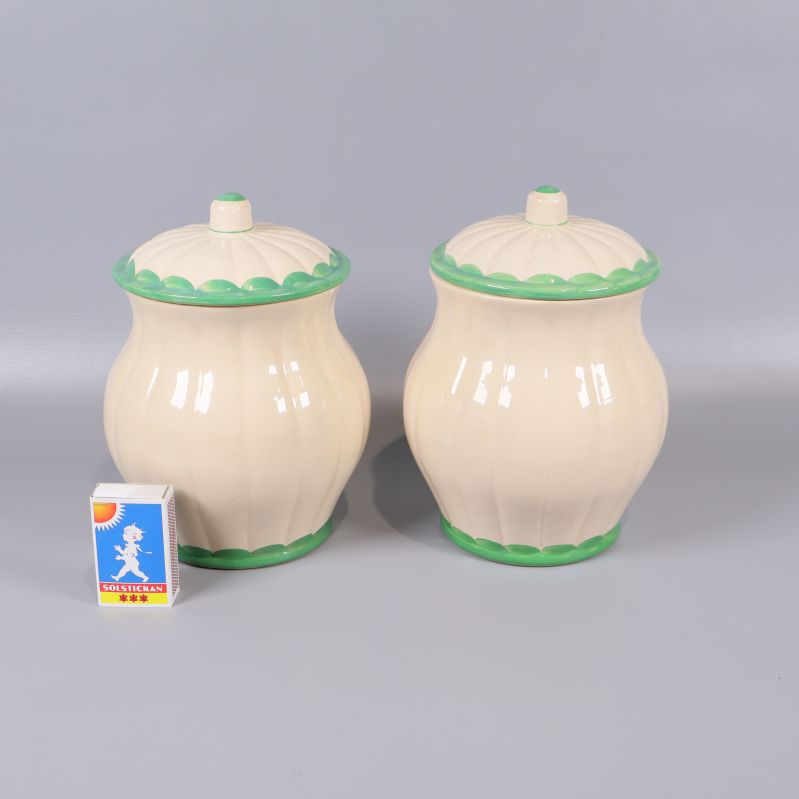 Baksidan av två burkar med lock, jämförelse med tändsticksask