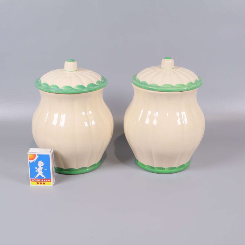 Burkar med lock bredvid tändsticksask för storleksjämförelse