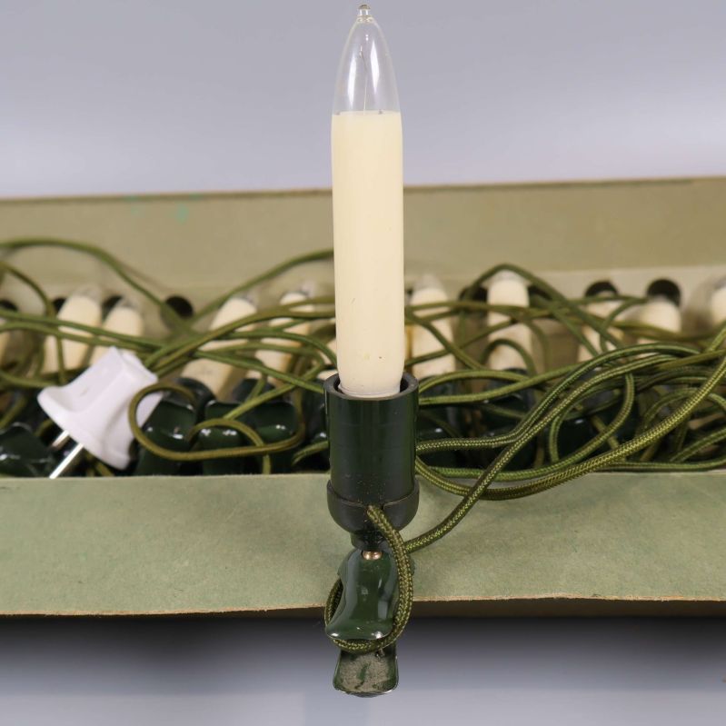 Närbild på gräddvitt elektriskt ljus i grön hållare