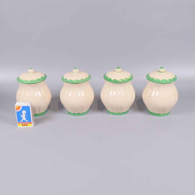 Baksidan av fyra kryddburkar med lock samt en tändsticksask som storleksreferens