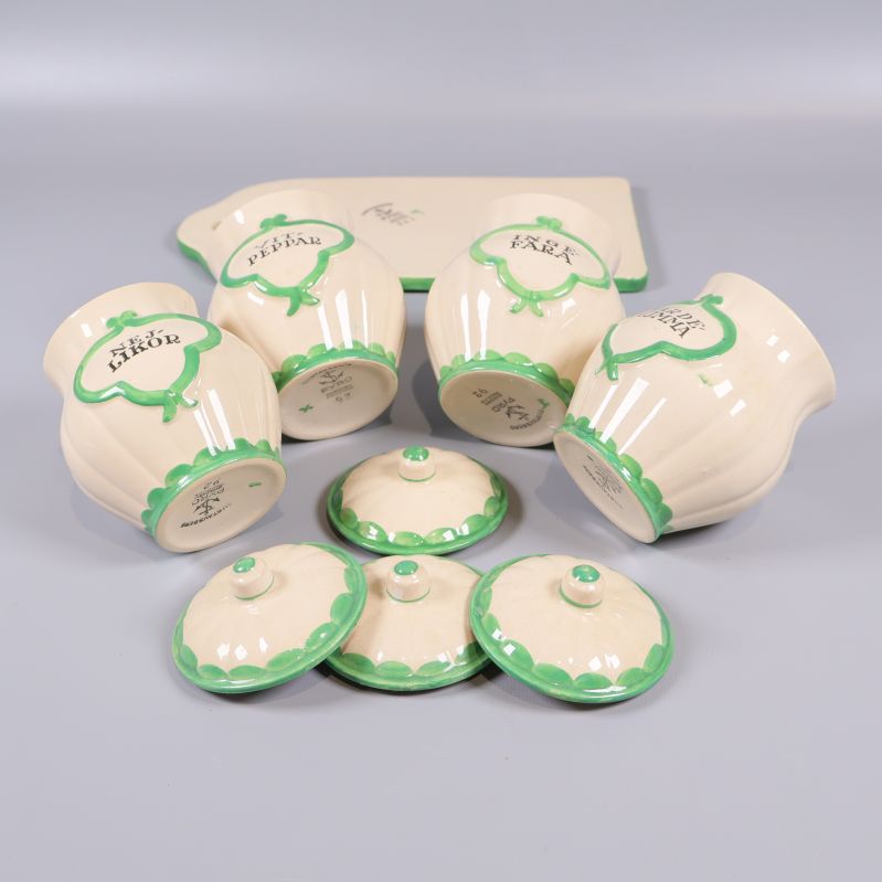 Kryddburkar och lock placerade på sidan tillsammans med skärbräda